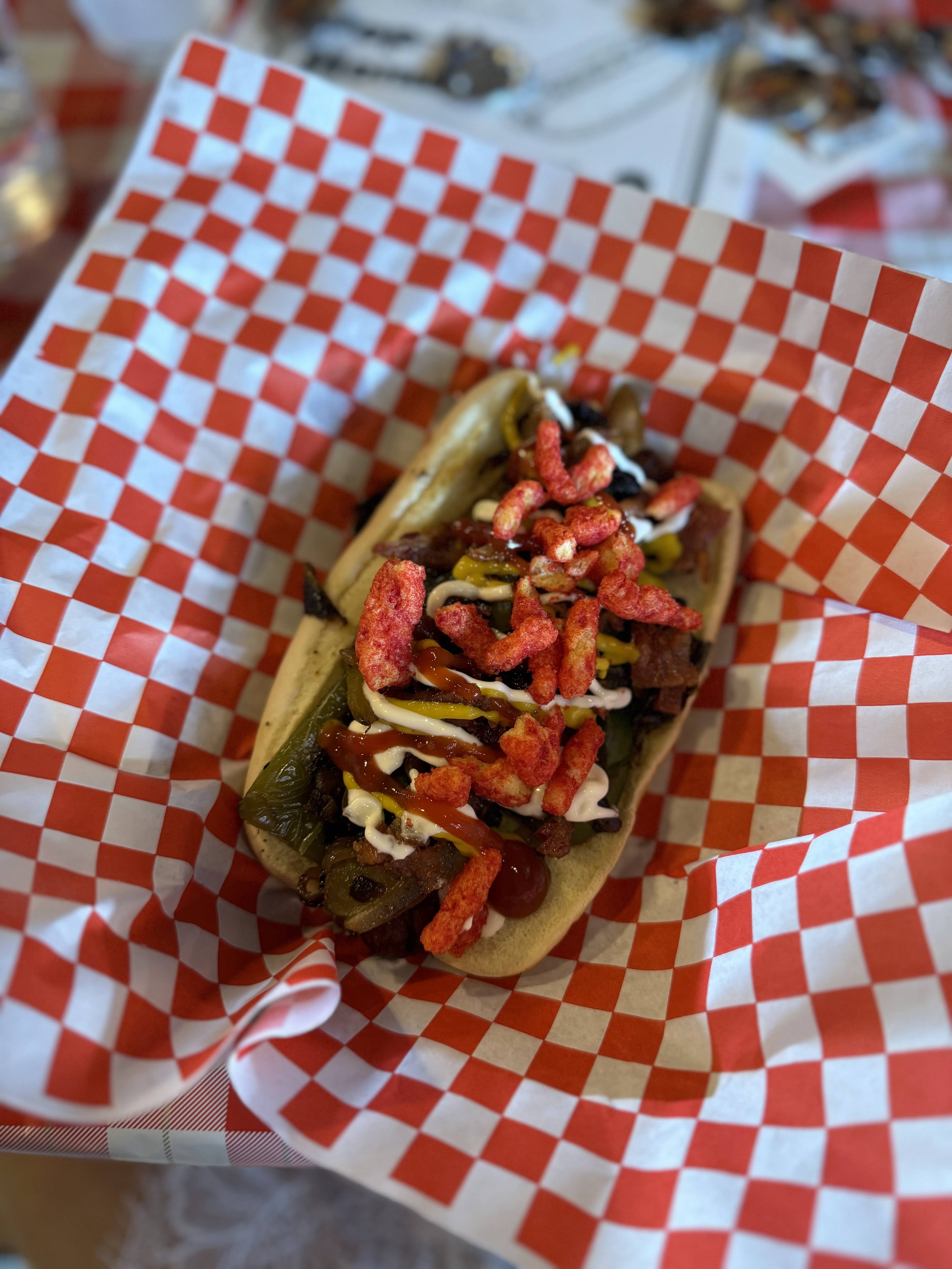 This is the L.A. Style Hot Dog w/ mustard, ketchup, mayo, grilled onions & sweet peppers, jalapeños, & bacon. A fun add was the flaming hot cheetos!